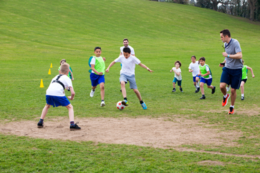 A coach on the field with students