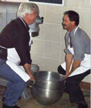 two workers lifting a heavy bowl together