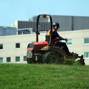 Groundskeeper driving a lawn mower