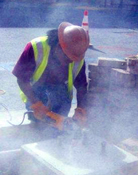Worker using a sander producing dust