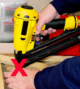 worker placed hand under nailer