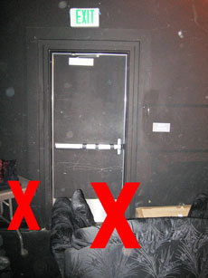 trash bags, boxes blocking an emergency exit back stage of a theater