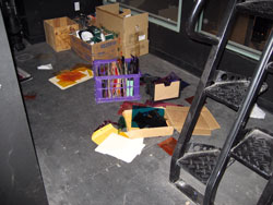 a sink in a theater green room with spilled water and electrical applicances plugged in.