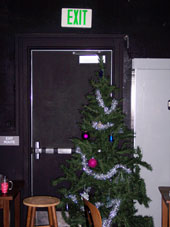 a christmas tree, a stool, and furniture blocking an exit