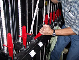 a worker with gloves on pulling down the rigging