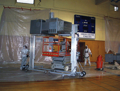 Asbestos workers in Tyvek suits working in plastic barrier setting