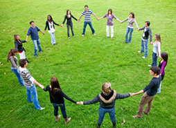 Group of men and women holding hands in a circle